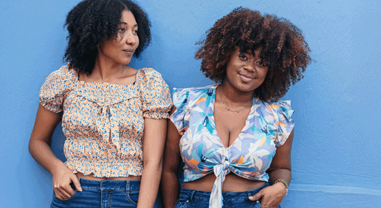 Two African-American Women Standing In Front Of A Wall